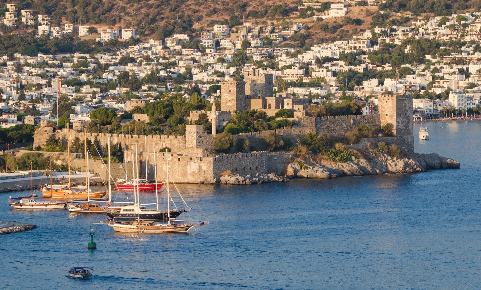 Bodrum Kalesi'nin limana uzanan burnu, önünde guletler ve arkada beyaz kasaba.