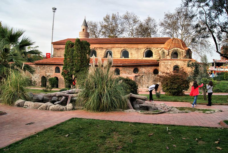 İznik’te ağaçlar ve bahçeler arasından görülen kırmızı tuğlalı Ayasofya yapısı.